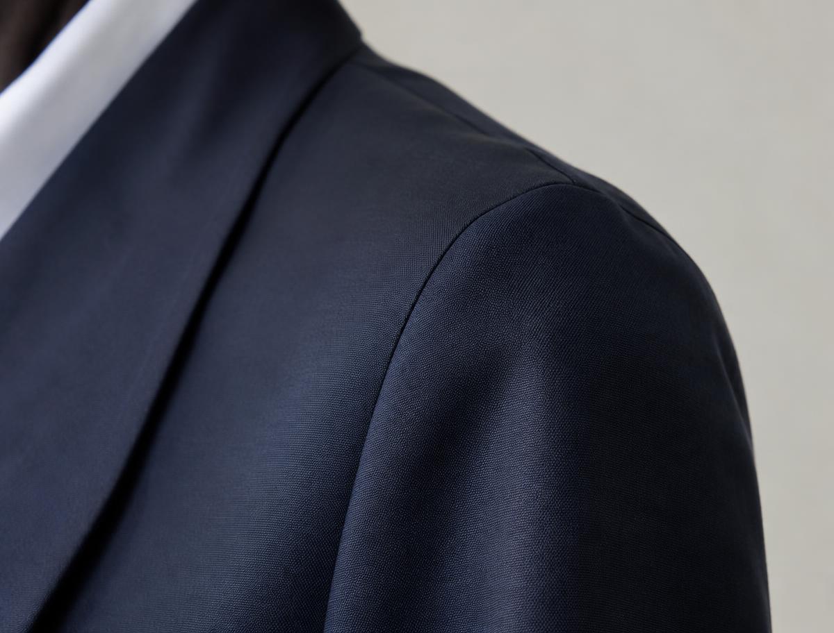 Close-up of a soft natural shoulder and hand-set sleeve head on a navy blazer