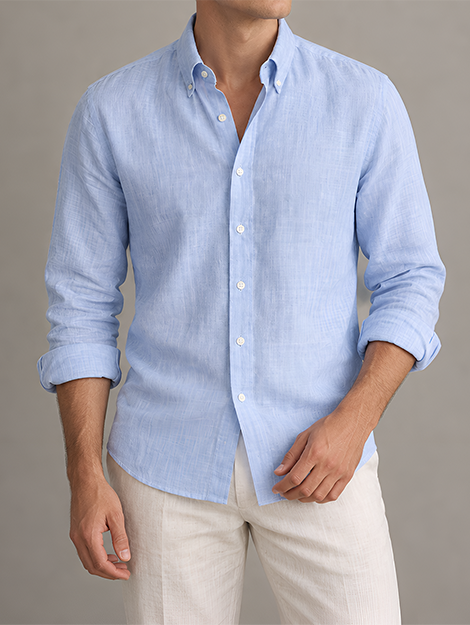 Man in a light blue linen shirt with button-down collar and cream trousers