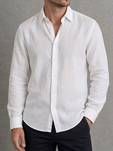 Man in a white linen shirt worn open collar with hands in pockets