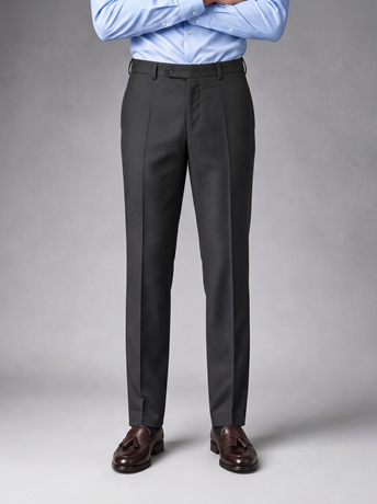Charcoal tailored wool trousers worn with a light blue shirt and brown tassel loafers